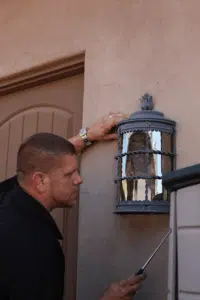 A pest control technician inspecting a potential entry point to seal scorpions out of a home