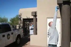 Pest control specialists sealing entry points to prevent scorpions from entering a home