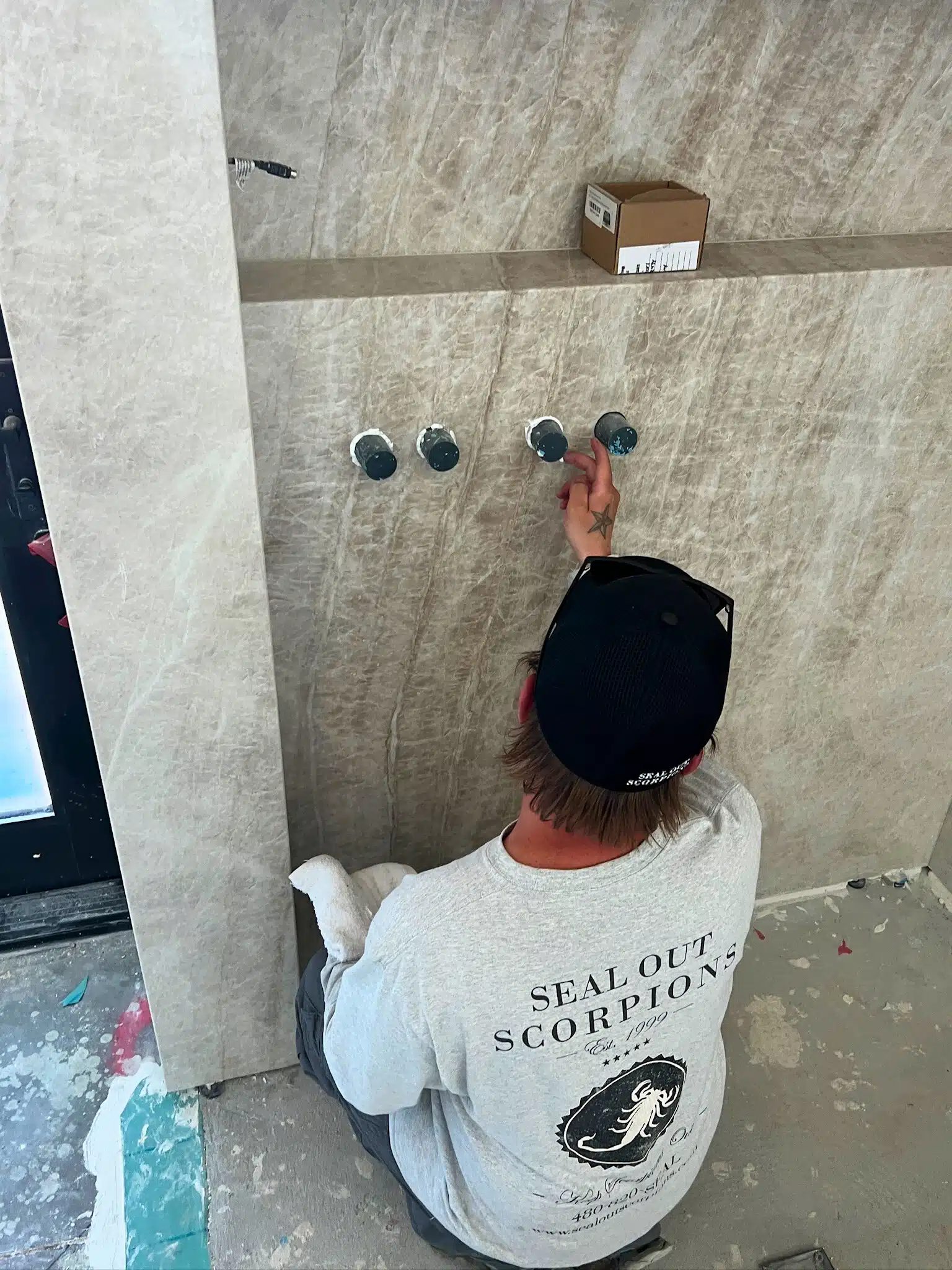 Technician applying a construction seal to prevent potential pest entry points