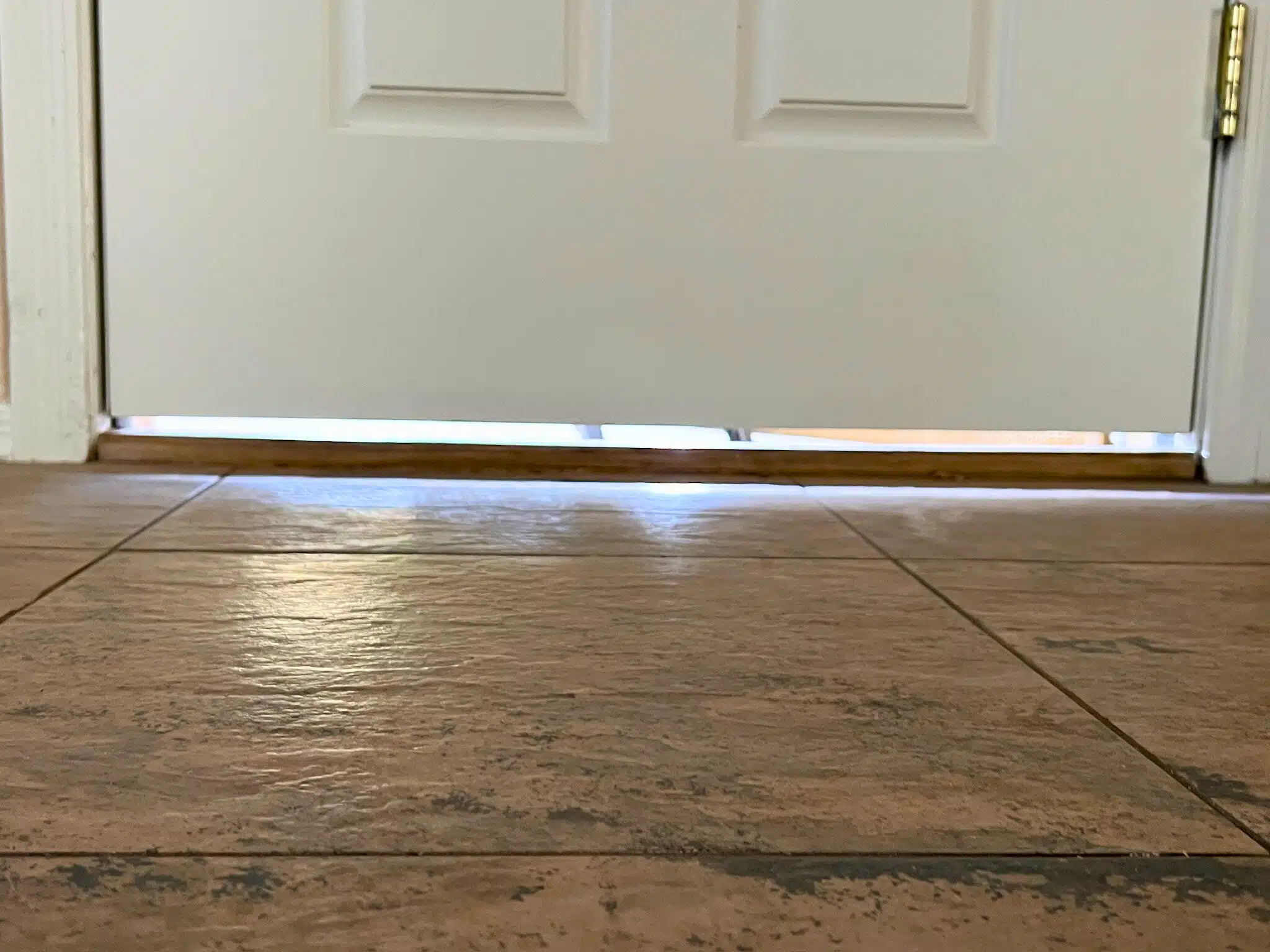 Visible gap beneath a door, illustrating common micro-air leaks that allow pests like scorpions to enter a home.